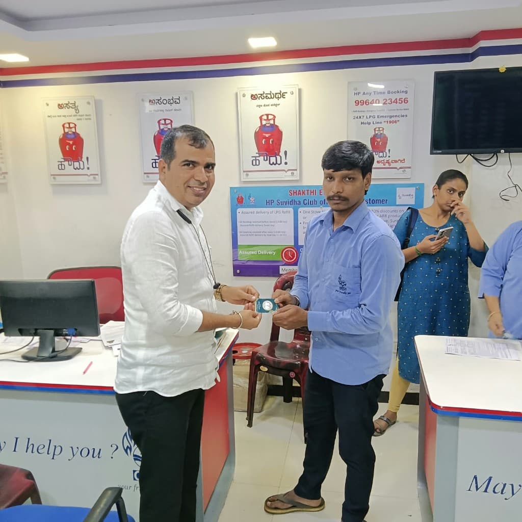 Membership card handover at an HP Gas customer desk